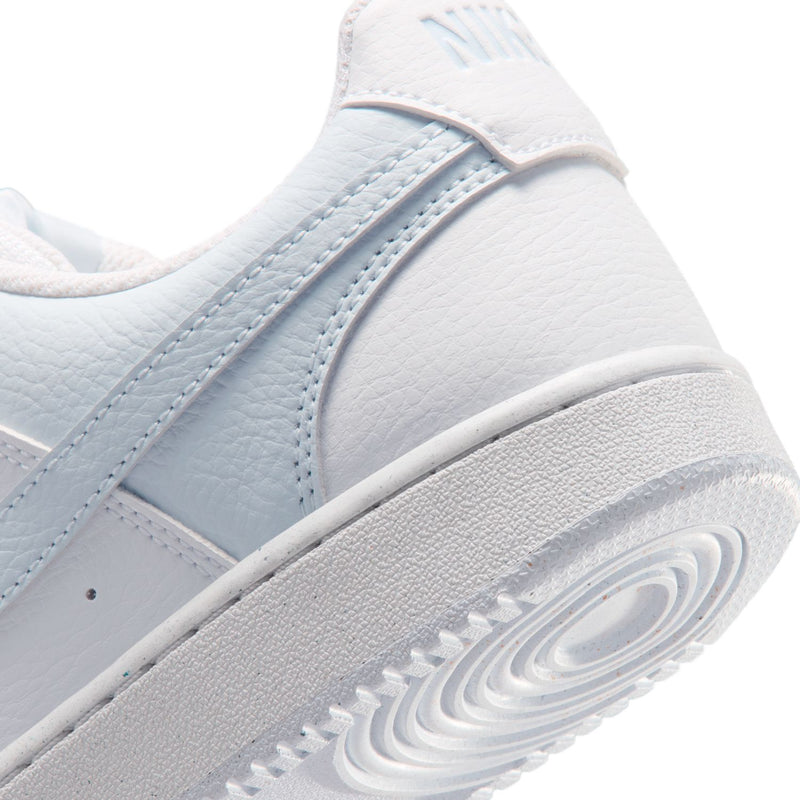 Close-up of women's white and light blue sneaker midsole and textured outsole.
