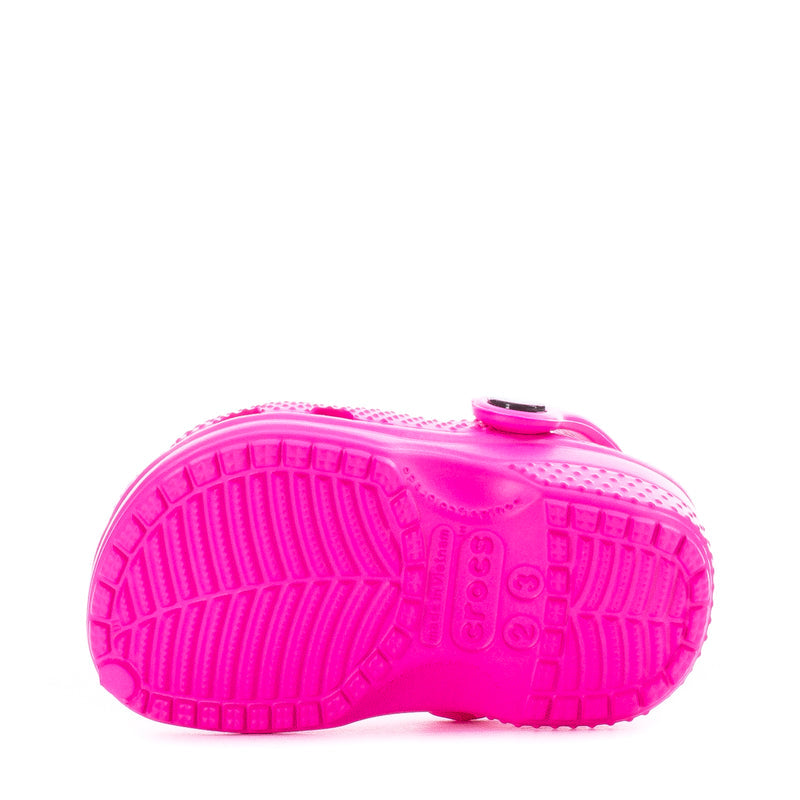 Bright pink infant Crocs clog outsole view with textured tread pattern