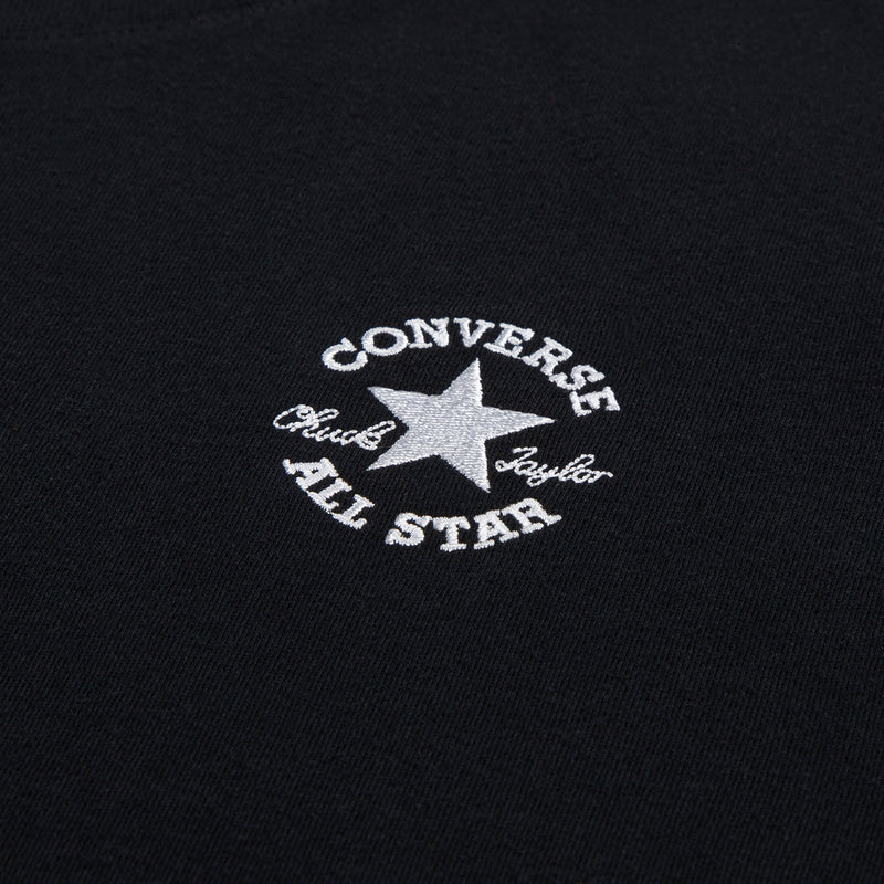 Black crewneck tee close-up: embroidered Converse star and All Star text