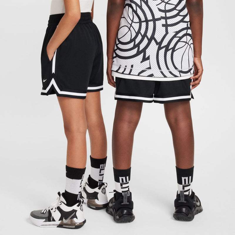 Black youth shorts with white trim, worn over sneakers with tall socks.