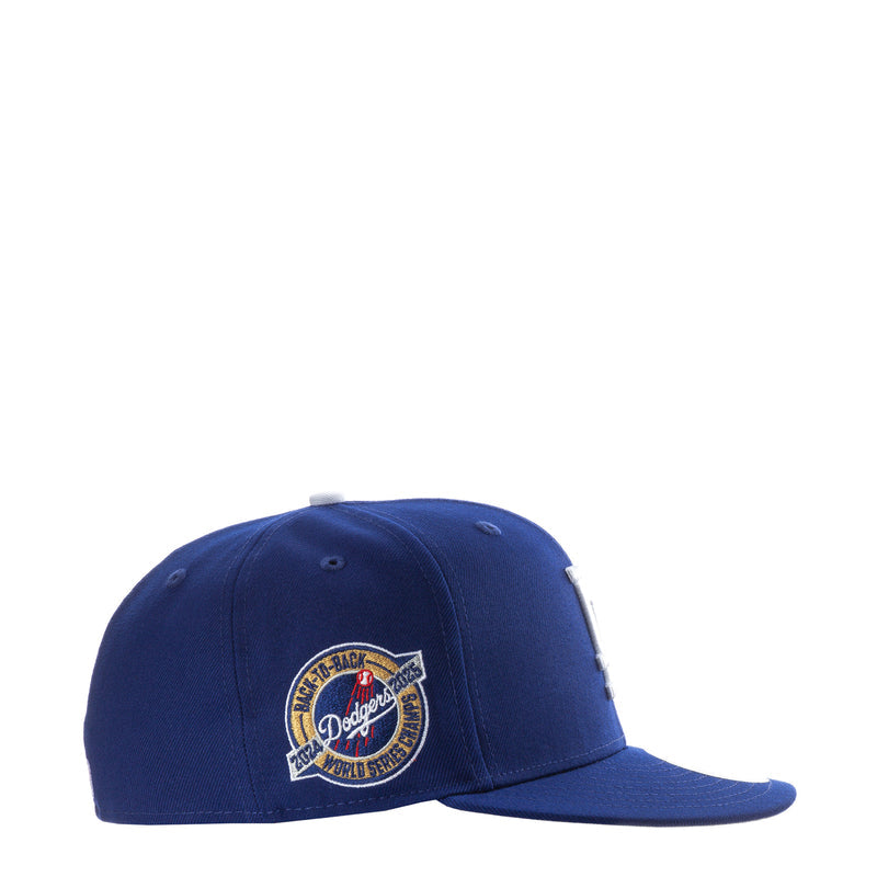 Royal blue baseball cap with circular Dodgers wordmark side patch.