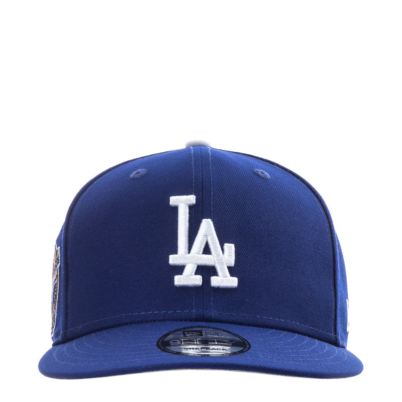 Royal blue baseball cap with white LA embroidered logo and New Era flag on brim