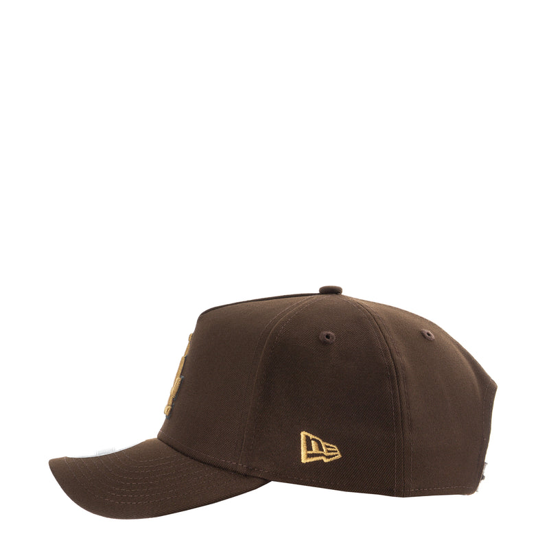 Brown A-frame baseball cap with small gold New Era flag logo on front