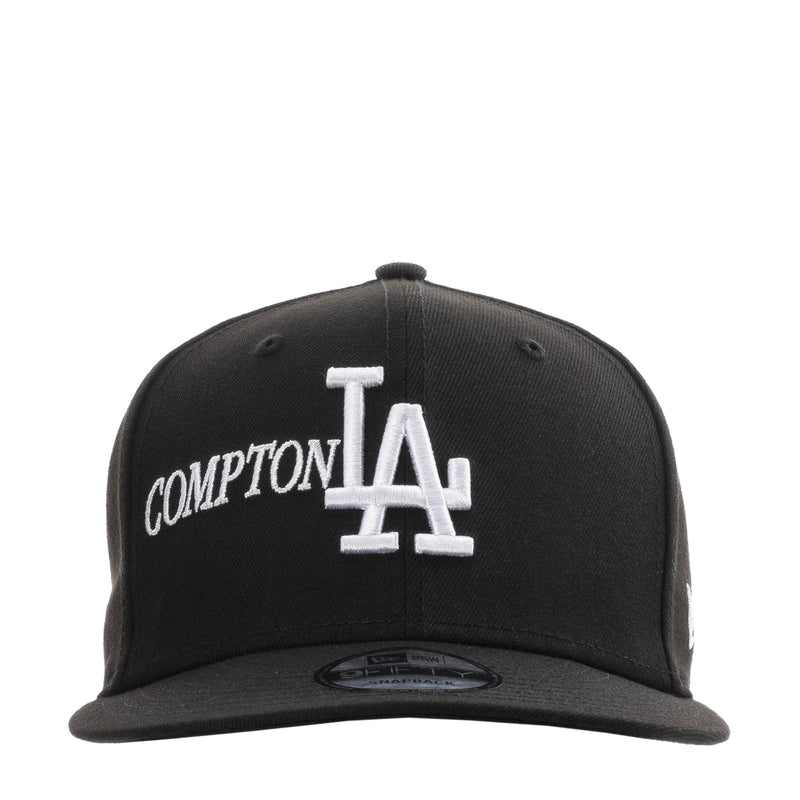 Black baseball cap with white Compton lettering and Los Angeles LA logo on front