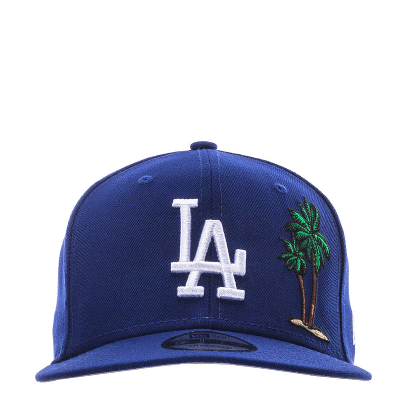 Royal blue baseball cap with white LA logo and green palm tree embroidery