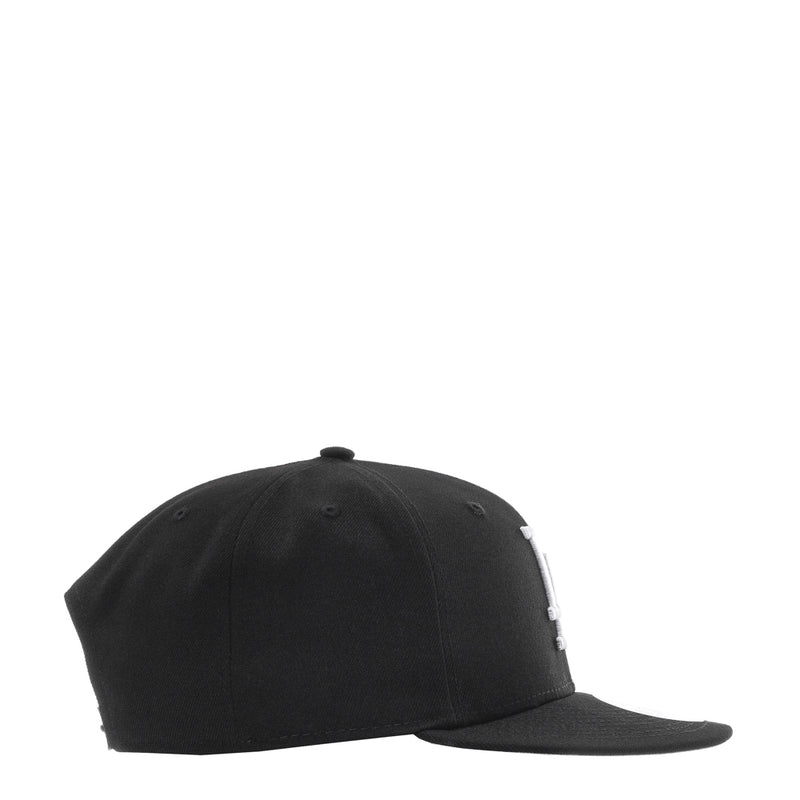 Black baseball cap with curved brim and stitched panels, side view
