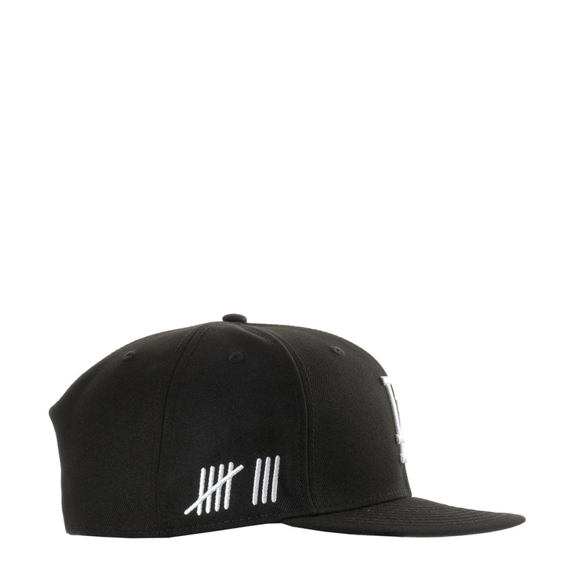 Black baseball cap with white striped graphic on front panel
