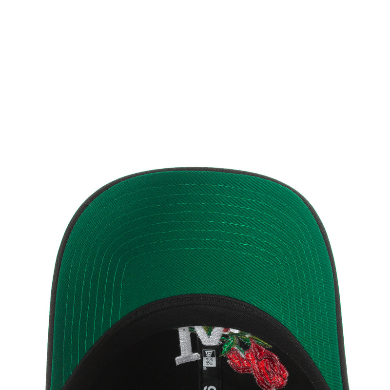 Green interior baseball cap with black underside brim and rose patch detail