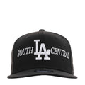 Black baseball cap with white LA and SOUTH CENTRAL embroidery, adjustable back strap