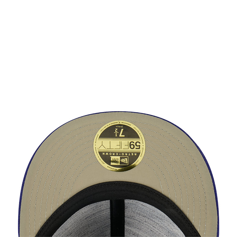 Light tan baseball cap with circular sticker patch on top and black inner band