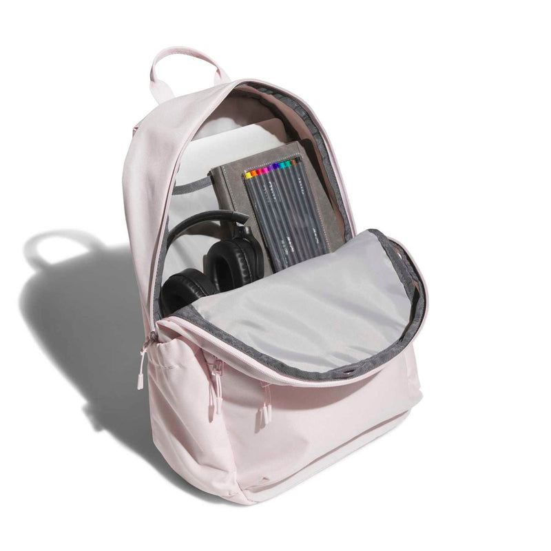 Light pink double-stacked backpack opened, showing inner sleeve for electronics and a headphone pocket.