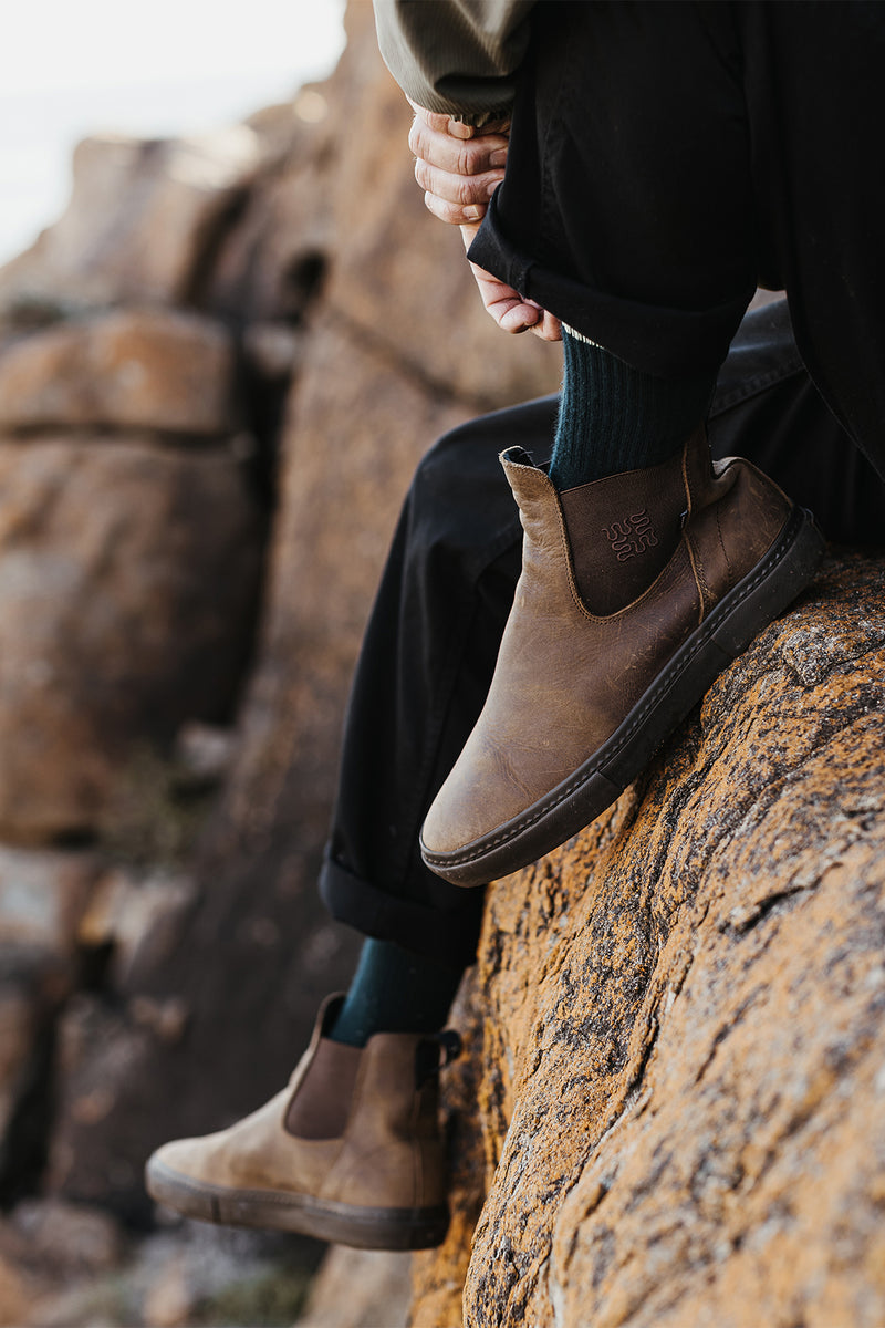 Dover II dark brown boot worn by a person perched on a rocky ledge outdoors