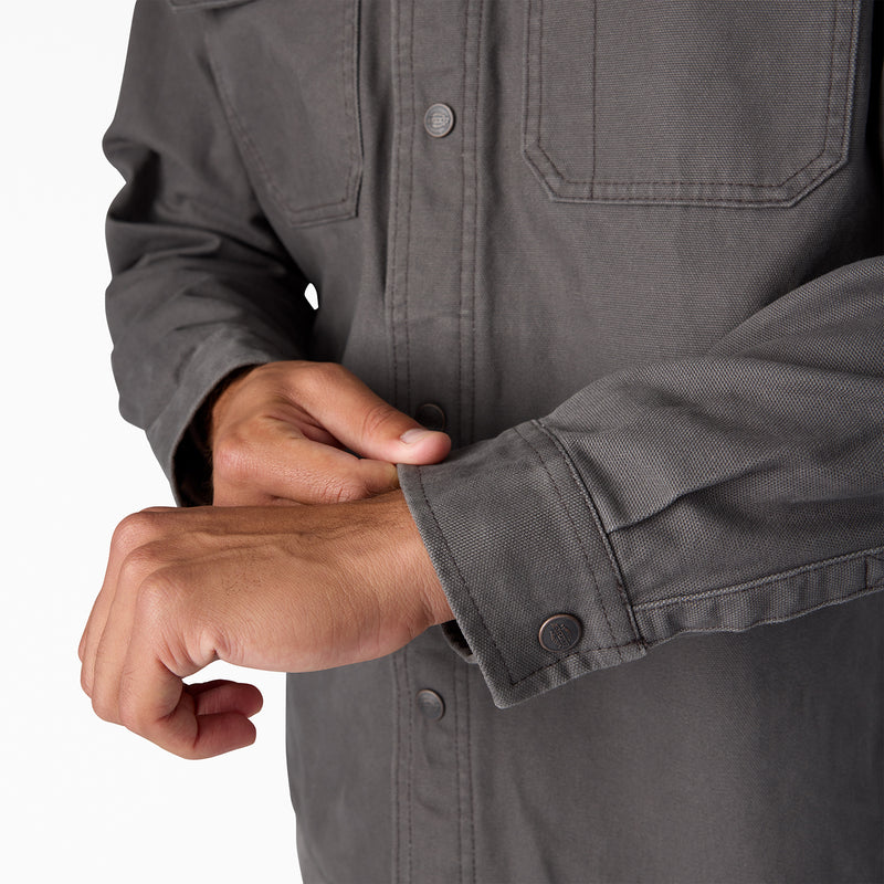 Men's duck shirt jacket cuff detail, dark gray with buttoned sleeve and visible stitching.