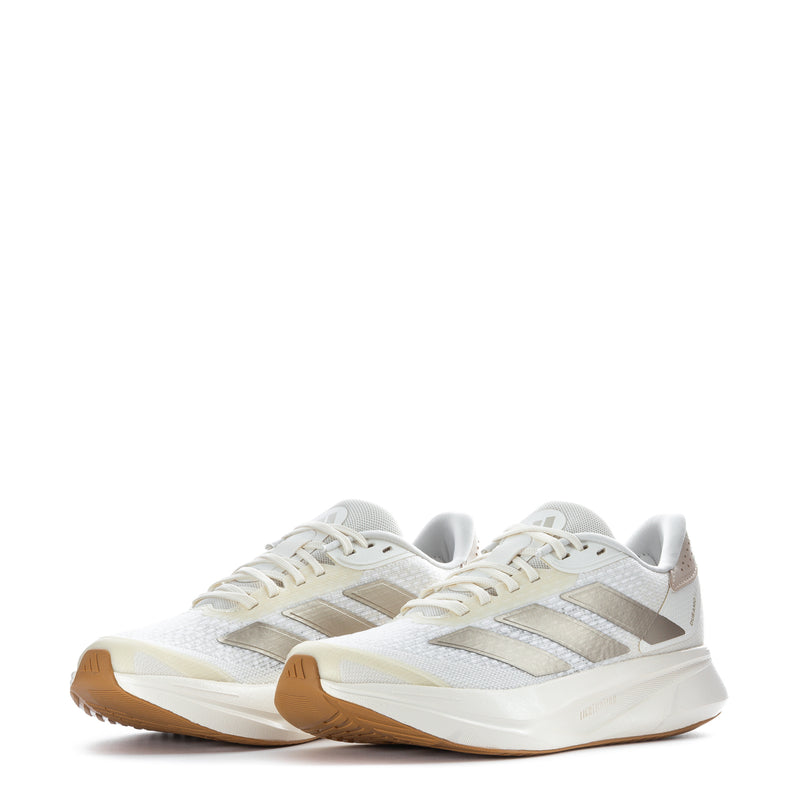 White women's running shoes with metallic stripes and lace-up design, gum outsole
