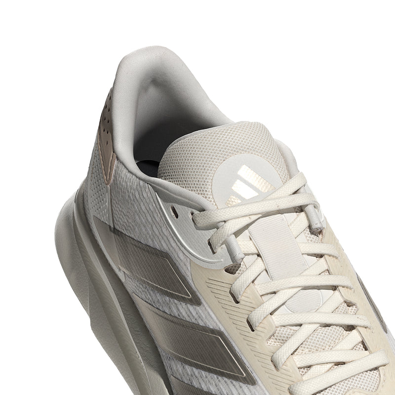 White lace-up running shoes with textured upper and gray metallic stripe detail