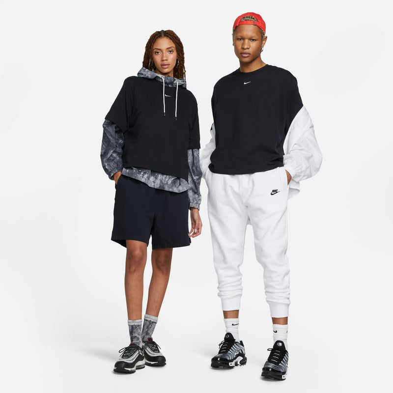 Women's black boxy T-shirt worn with shorts and sneakers, Nike swoosh