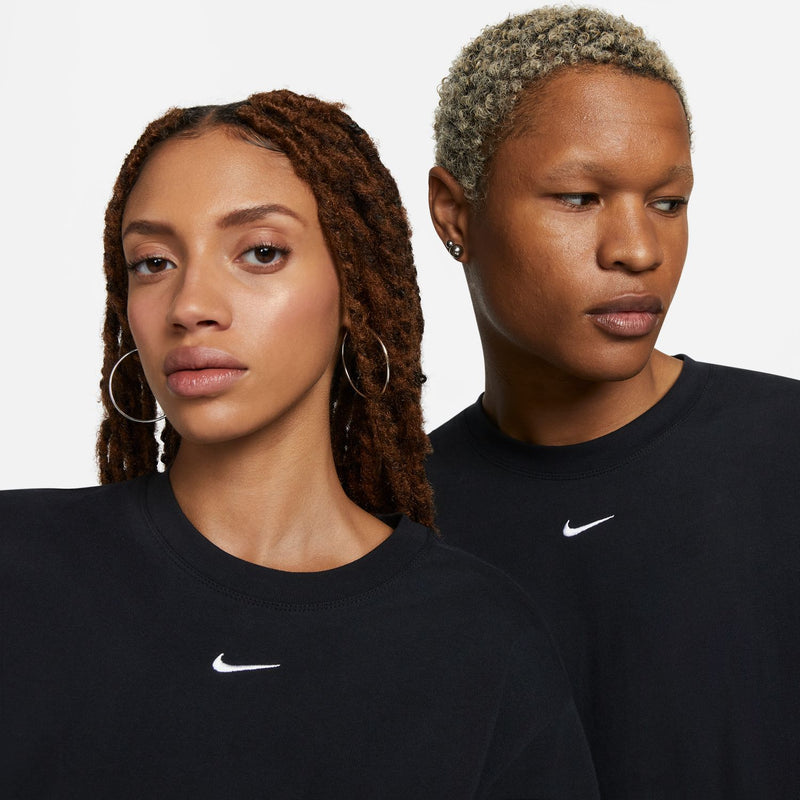 Women's black boxy T-shirt with small white Nike swoosh near neckline