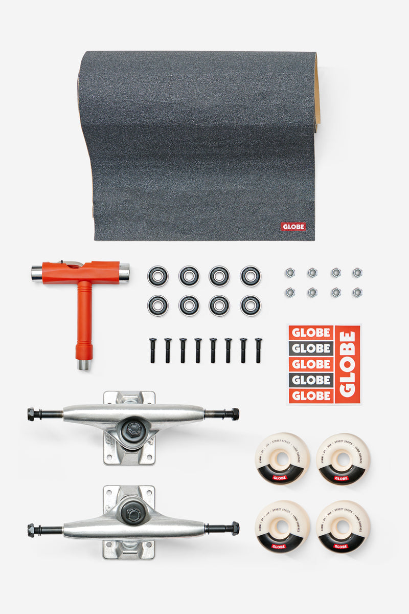 Everything But The Deck 5.0 kit laid out with dark griptape sheet, red T tool, Slant trucks, bearings, hardware, wheels, and Globe decals