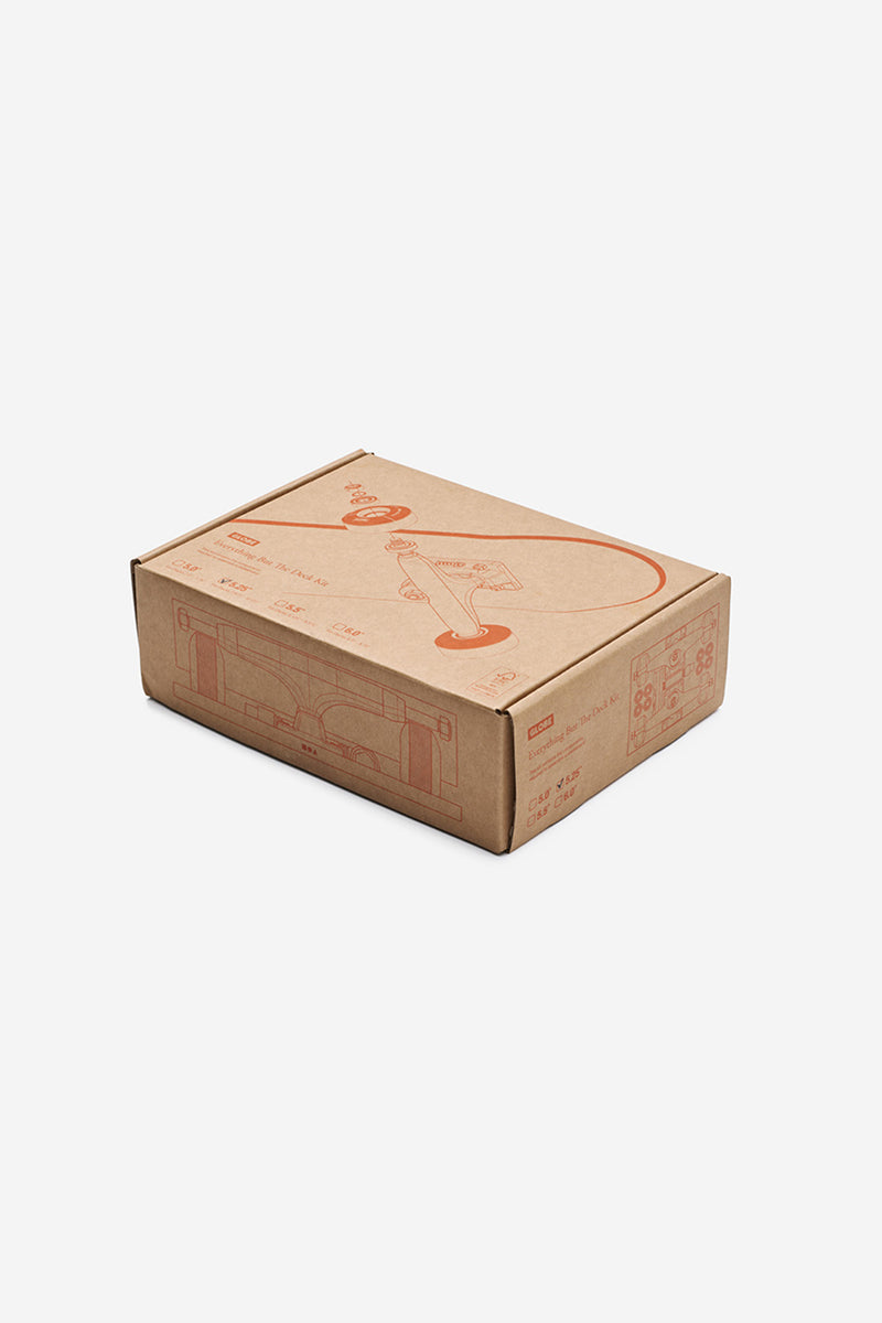 Slant trucks grip tape wheels bearings deck hardware and a T-tool laid out beside the kit box