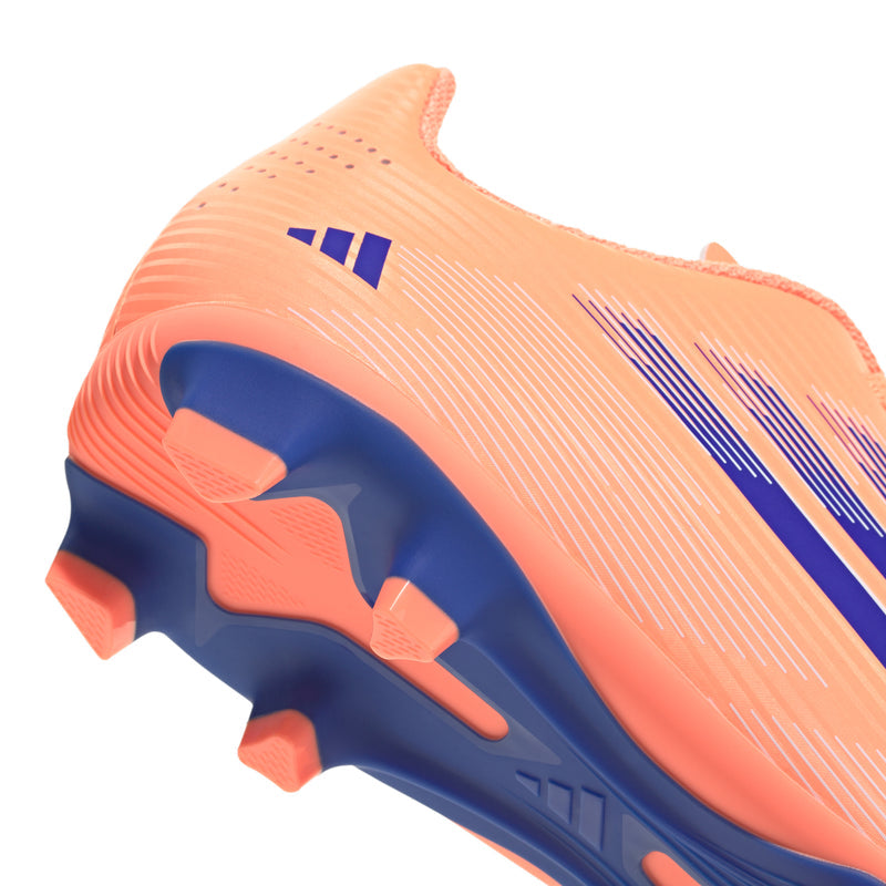 Youth FG soccer cleats, orange upper with blue outsole details and molded heel studs.