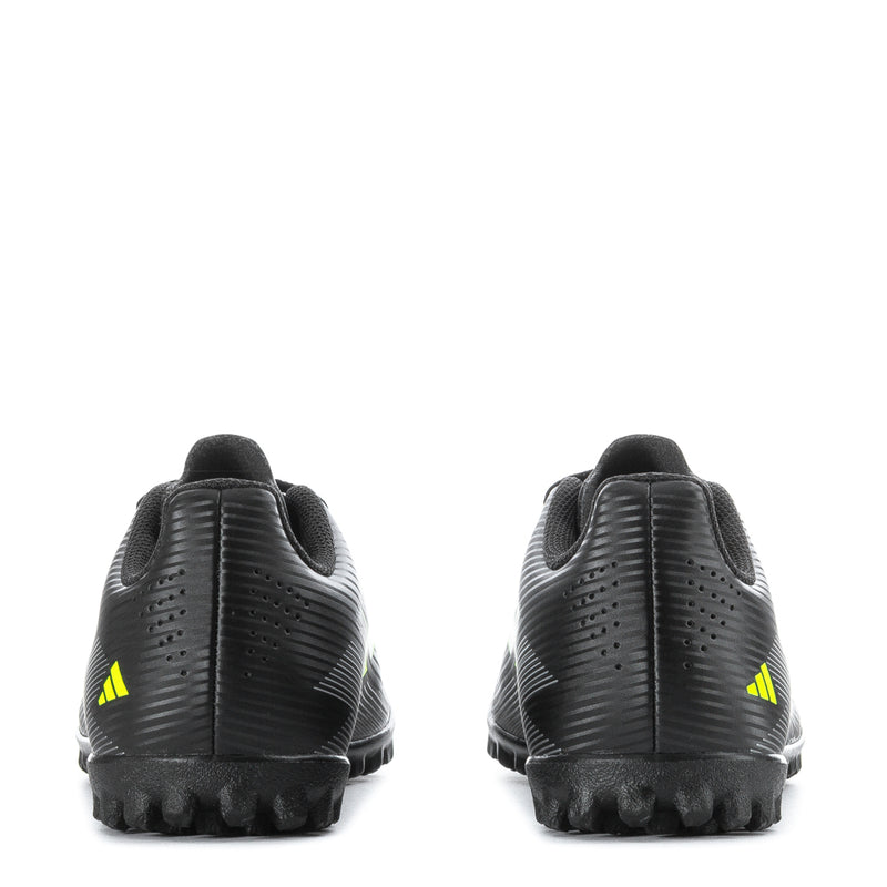Youth black soccer cleats rear view with neon green heel accents and rubber stud sole