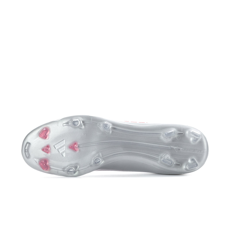 Underside of men’s white soccer cleat with molded studs and red accents