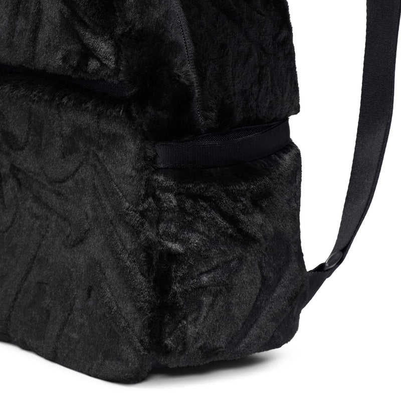 Black faux fur mini backpack with side panel seam and strap webbing.