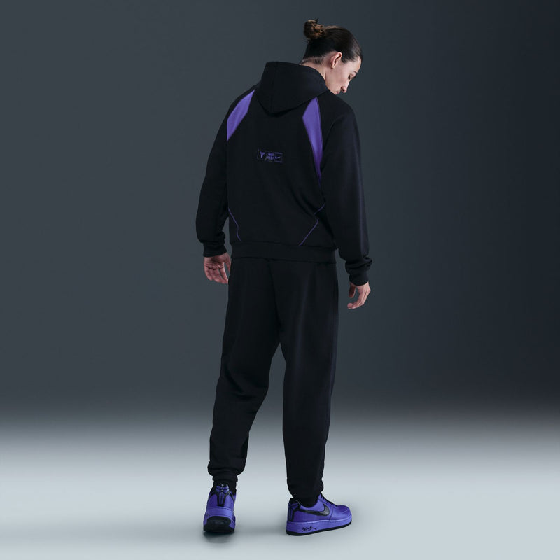 Black track pants back view with elastic cuffs and small purple logo on leg
