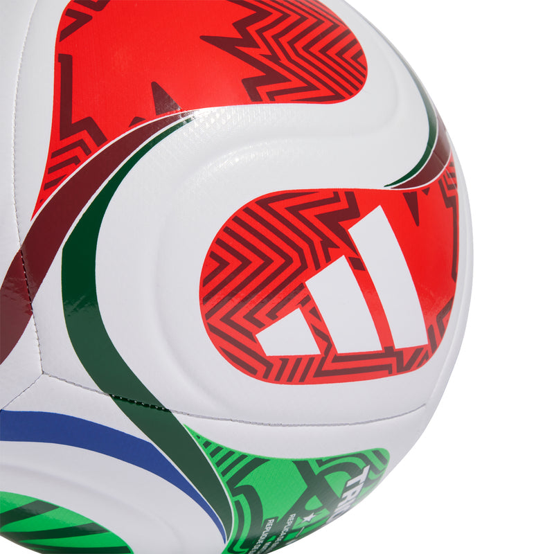 Close-up training football panel with red, green, and black geometric patterns on white.