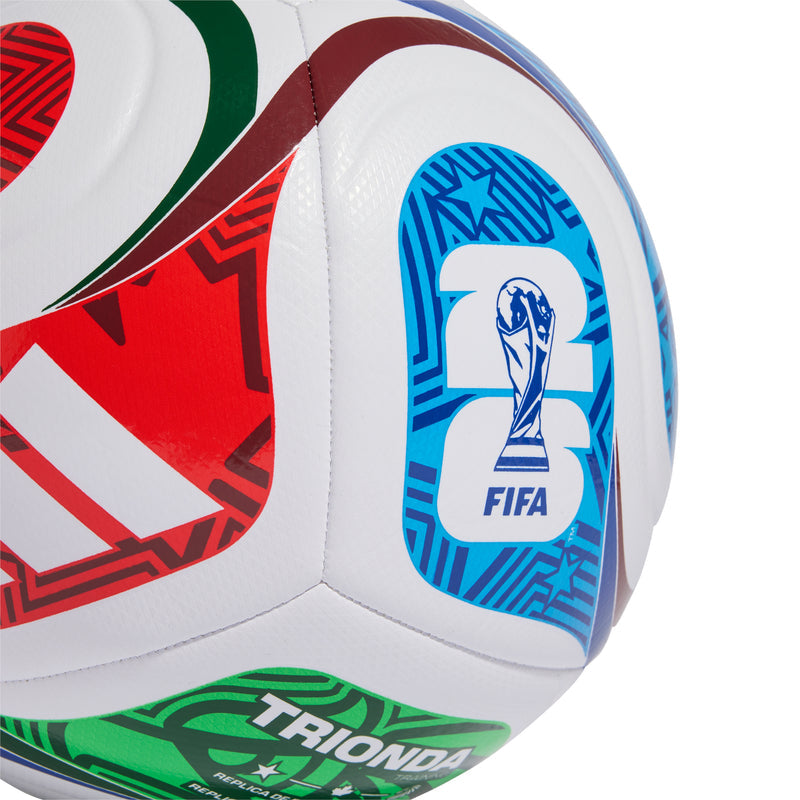 White training football with blue FIFA shield logo and green TRIONDA band.