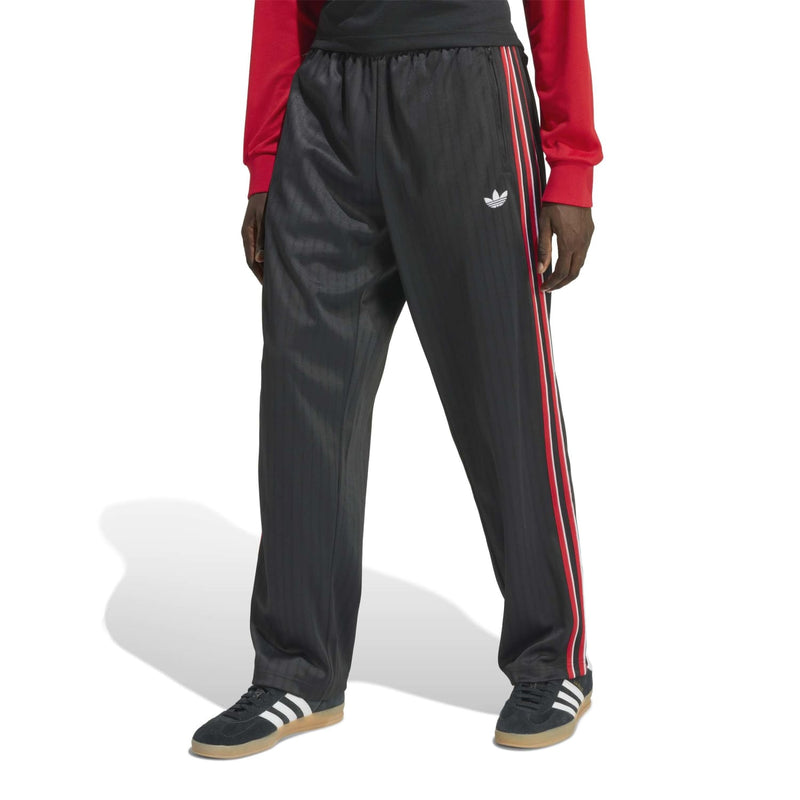 Black track pants with elastic waist, small logo, and red-and-white side stripes