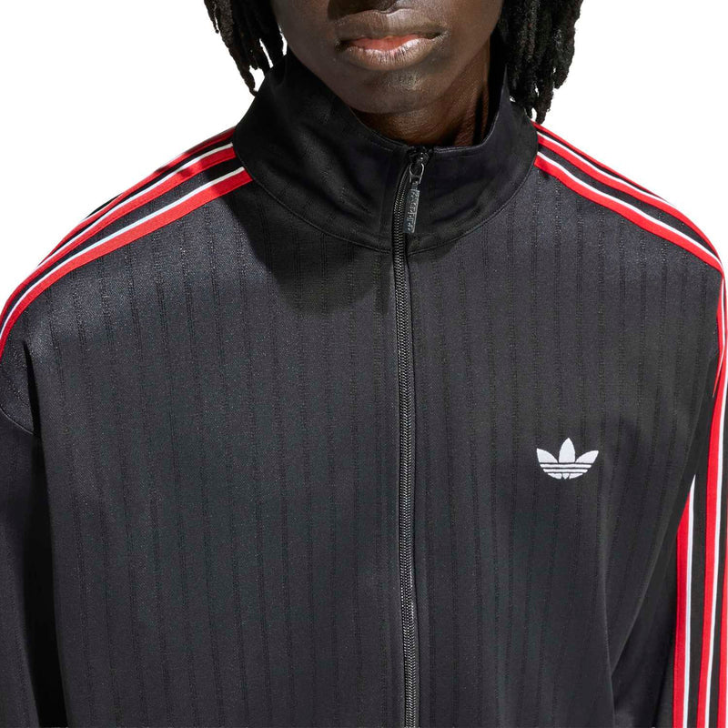 Men's black track jacket close-up: white trefoil-style logo, red-and-white shoulder stripes