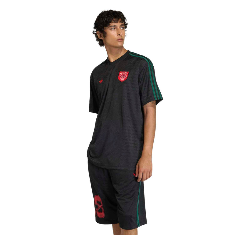 Men's black football jersey, green sleeve stripes, red crest and small red logo