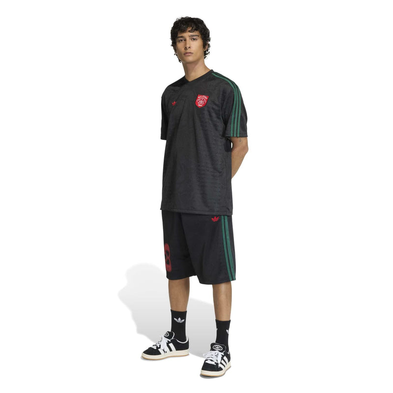 Men's black football jersey with green trim stripes and red crest on front