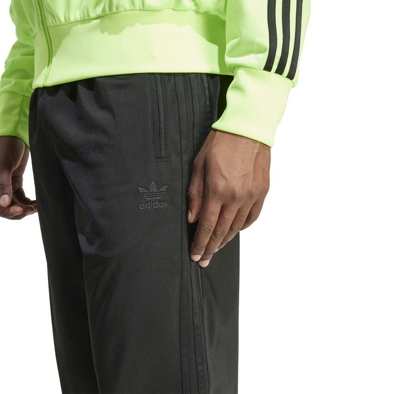 Black track pant with adidas logo and stitched vertical seam detail.