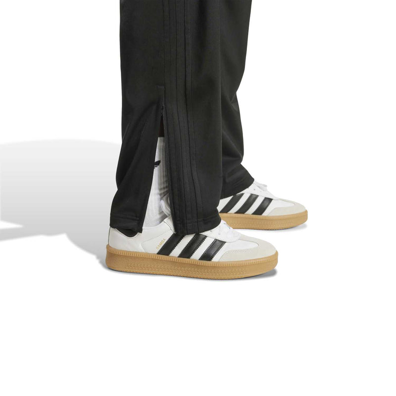 Black track pant hem with split detail and elastic ankle cuff.