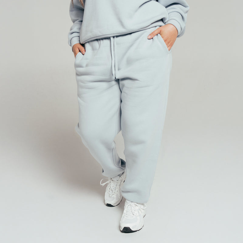 Women's light blue jogger fleece pants, side view, tapered legs and drawstring
