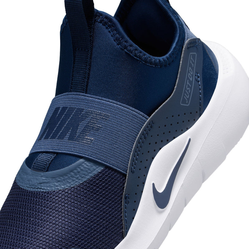 Kids navy slip-on shoe close-up with elastic collar, strap, and Nike logo