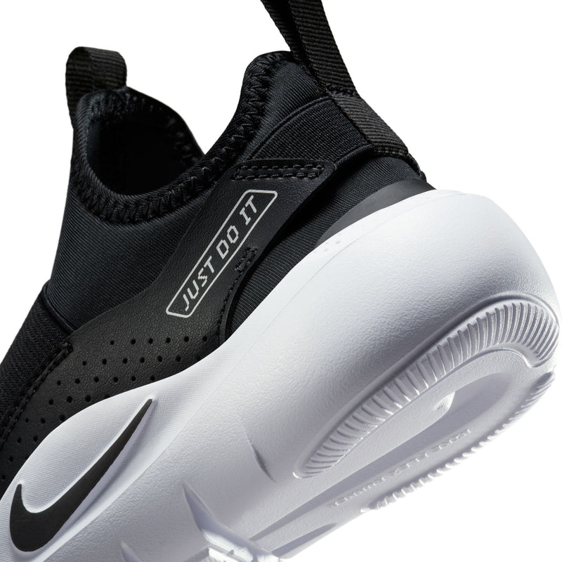 Kids black slip-on shoes close-up, showing 'JUST DO IT' strap and Swoosh