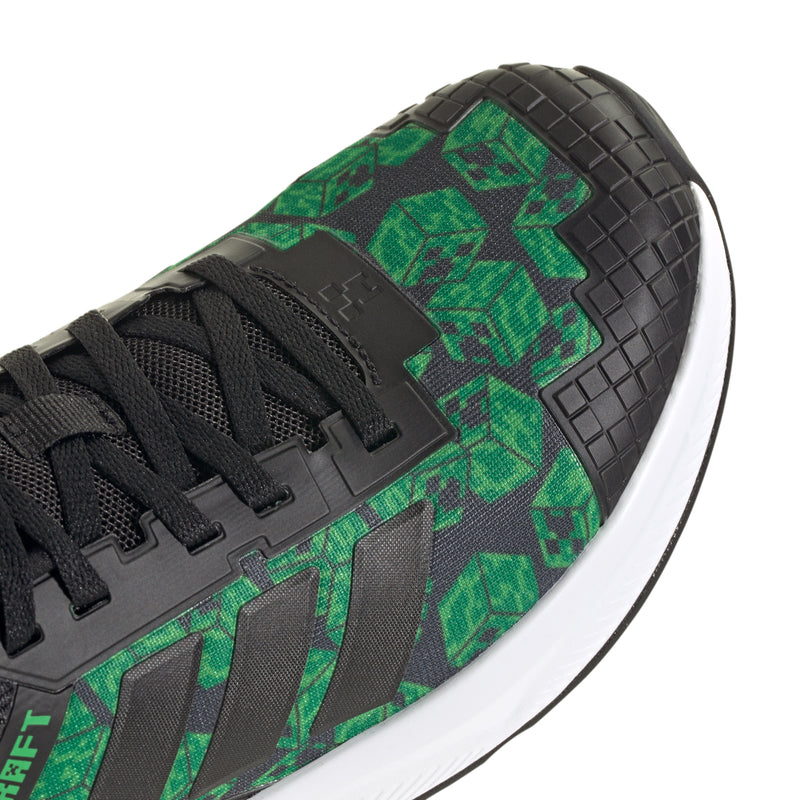 Youth sneaker toe and side close-up, black mesh with green graphic panel