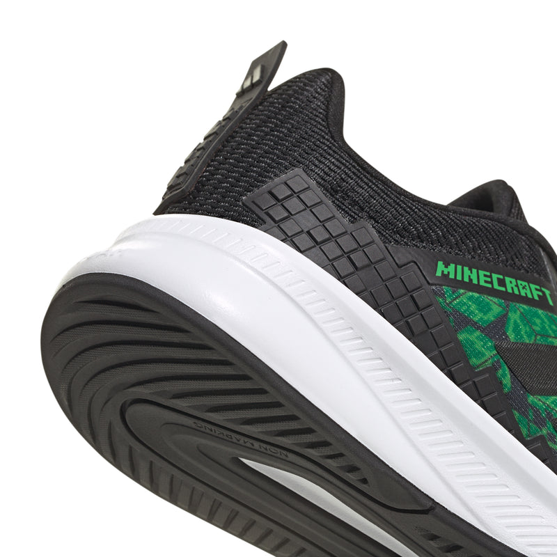 Youth sneaker sole close-up, black tread with green Minecraft branding and white midsole