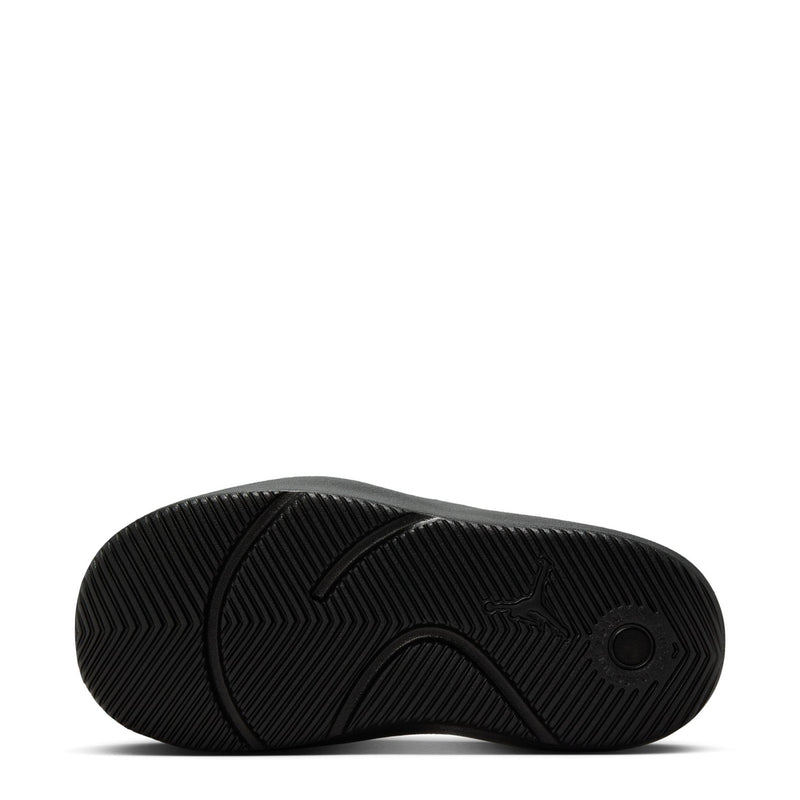 Black youth slide sandals outsole with textured tread pattern and circular traction mark.