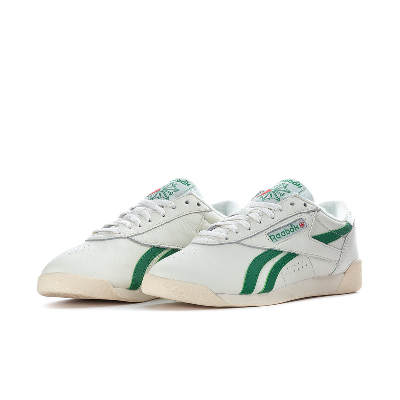 Women's white low-top Reebok sneakers with green side stripes and tan sole