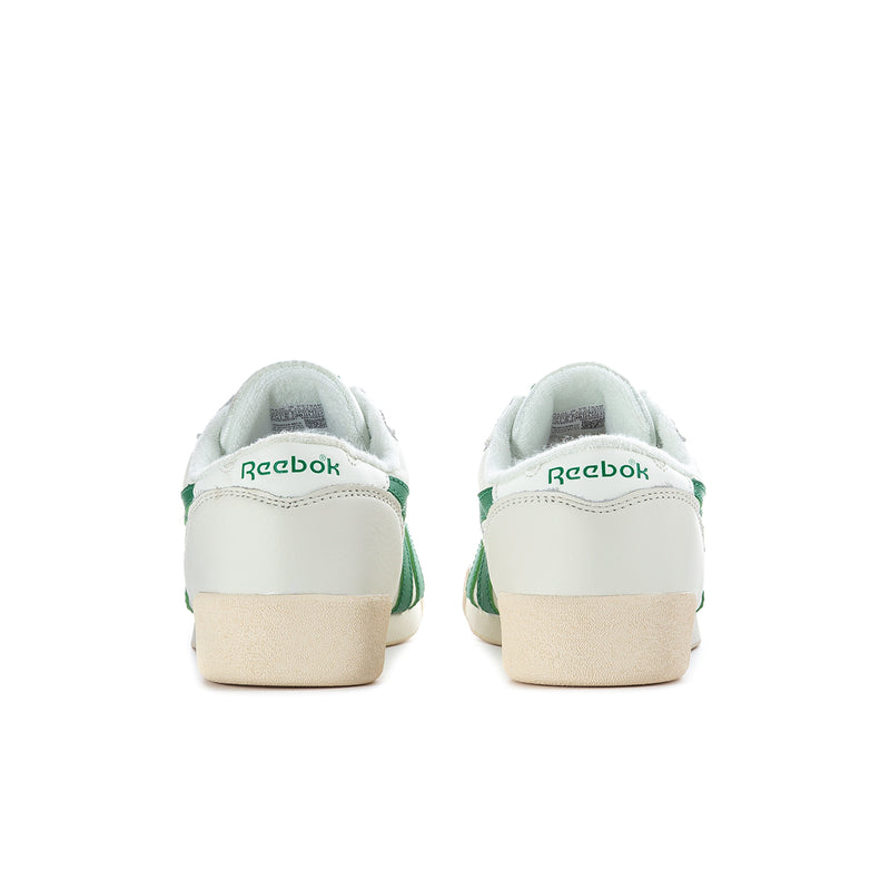 Back view of white Reebok sneakers with green heel tabs and tan outsole