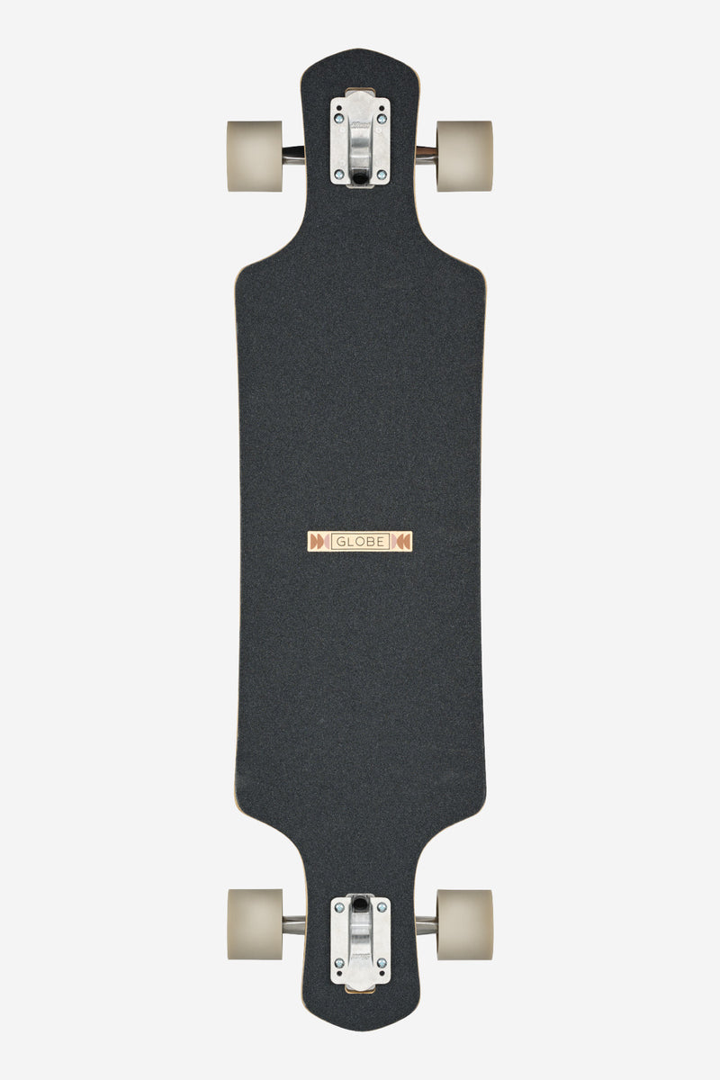 Underside view of Geminon 37.5 longboard in Arid showing black grip deck, beige wheels and metal trucks.