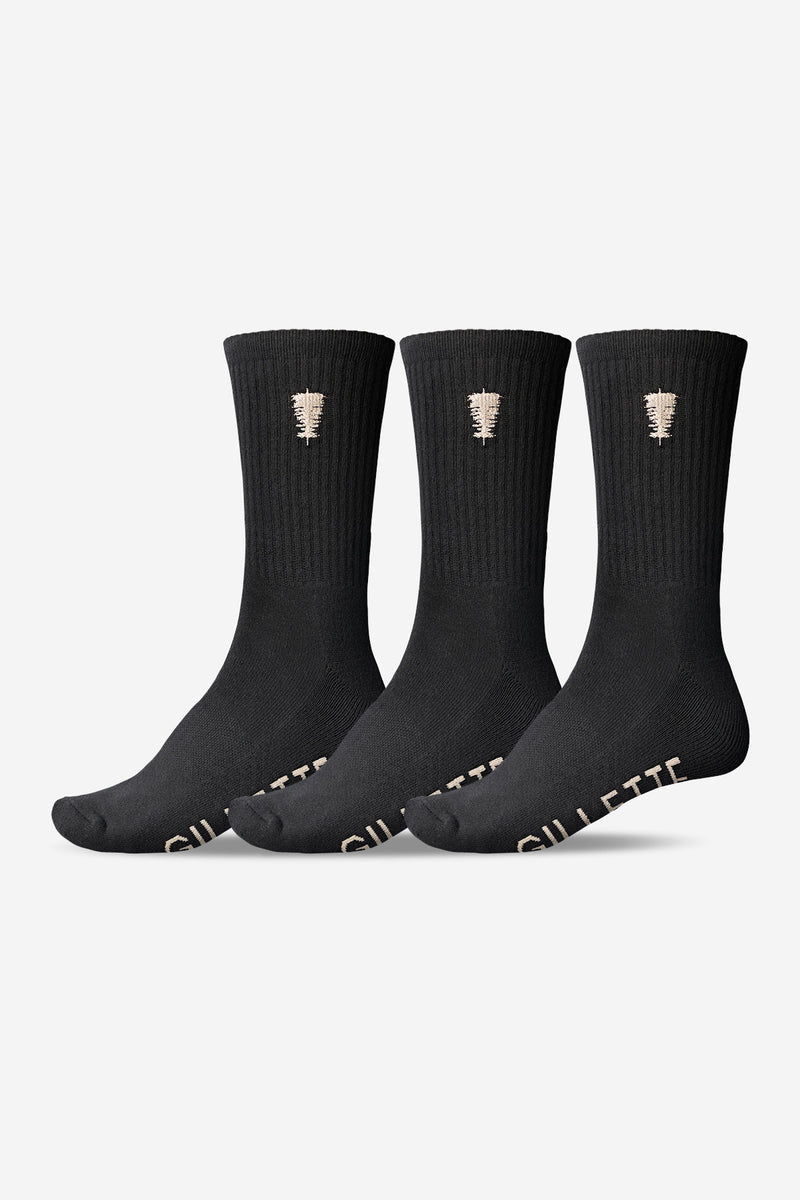 Three black crew socks with a small beige logo on the cuff and GILLETTE lettering on the toe.