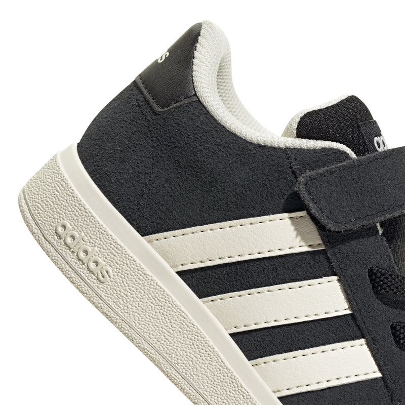 Black toddler sneaker close-up, white stripes and Velcro strap on cuff