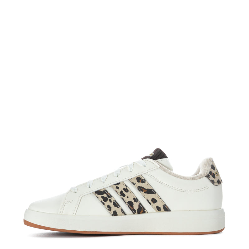 Youth white adidas sneakers with leopard side stripes, lace-up front, tan sole.