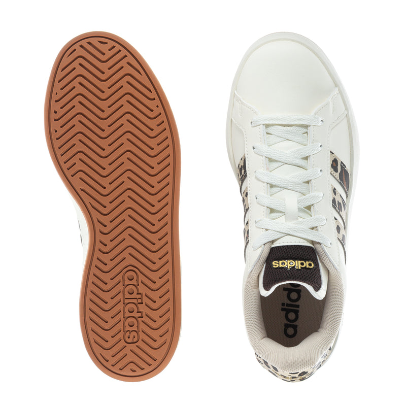Youth white sneaker outsole and heel, showing tan rubber tread.