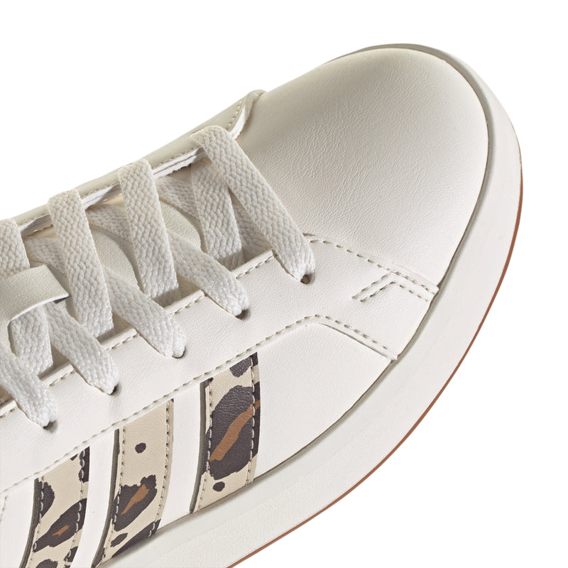 Close-up of youth white leather sneaker with white laces and leopard stripe panel.
